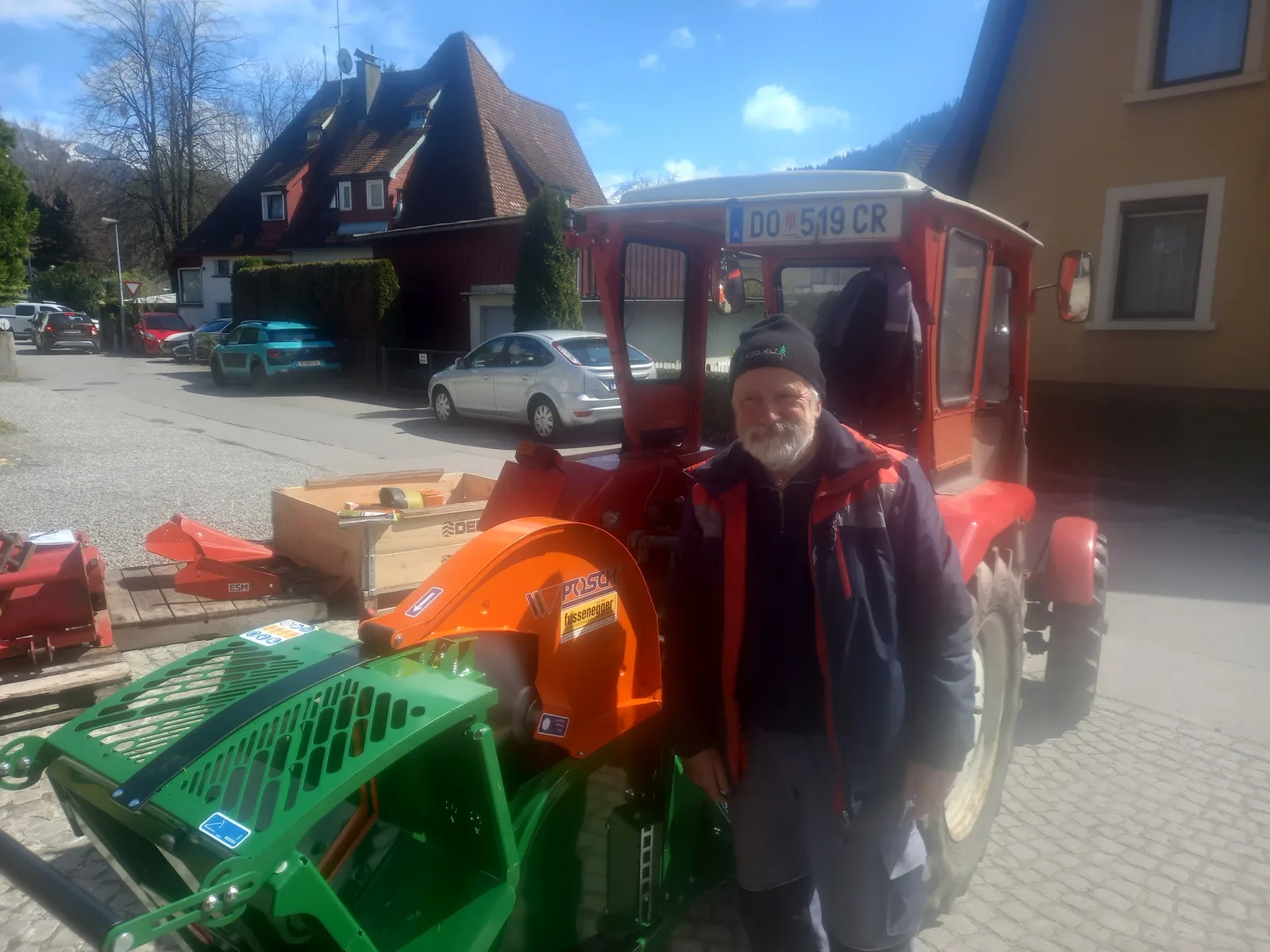 Hannes Fussenegger steht neben einem Traktor mit angebautem Häcksler